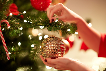 Image showing hands decorating christmas tree with ball