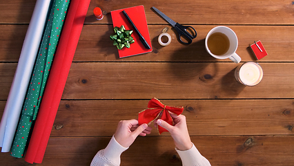 Image showing hands with bow for christmas gifts wrapping
