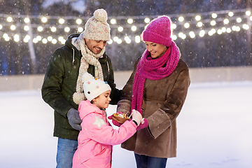 Image showing happy family eating pancakes on skating rink