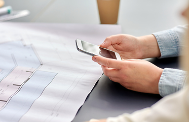 Image showing hands with smartphone and blueprint at office