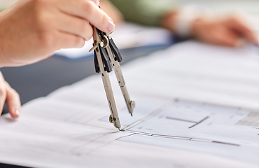 Image showing architect with blueprint and drafting compass