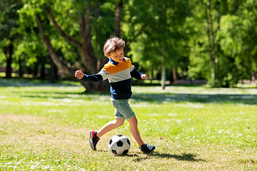 Image showing happy little boy with ball playing soccer at park