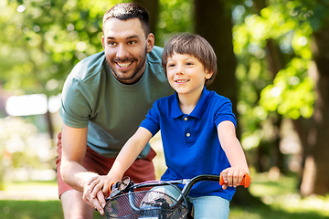 Image showing father teaching little son to ride bicycle at park