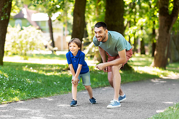 Image showing happy father and son compete in running at park