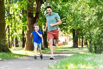 Image showing happy father and son compete in running at park