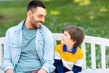 Image showing father with son sitting on park bench and talking