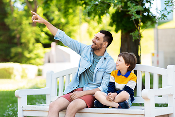 Image showing father showing something to son sitting on bench