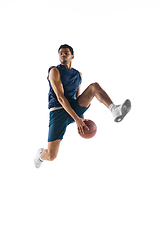 Image showing Young arabian basketball player of team in action, motion isolated on white background. Concept of sport, movement, energy and dynamic.