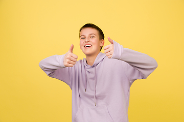 Image showing Caucasian girl\'s portrait isolated on yellow studio background with copyspace