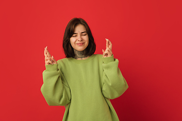 Image showing Caucasian woman\'s portrait isolated on red studio background with copyspace