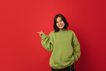 Image showing Caucasian woman\'s portrait isolated on red studio background with copyspace