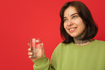 Image showing Caucasian woman\'s portrait isolated on red studio background with copyspace