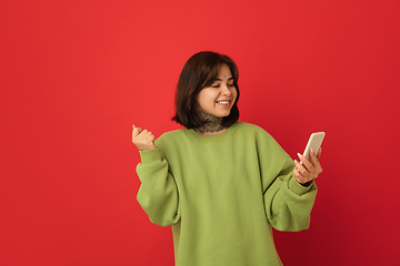 Image showing Caucasian woman\'s portrait isolated on red studio background with copyspace