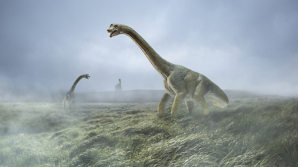 Image showing Dinosaurs huge higth walking through the jungle, foggy mountains