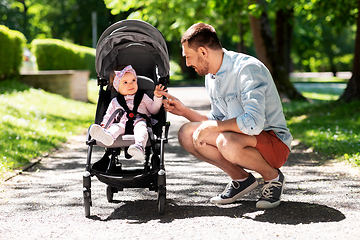 Image showing happy father with child in stroller at summer park