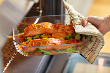 Image showing woman cooking food in oven at home kitchen