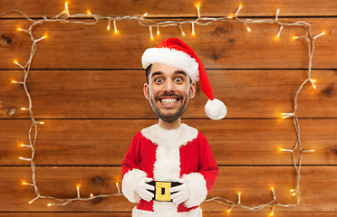 Image showing happy santa over garland on wooden background