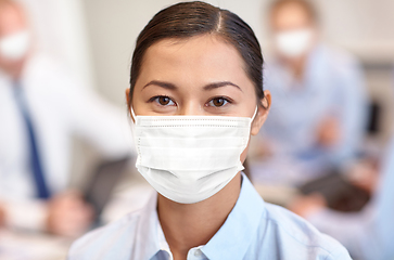 Image showing businesswoman in face protective mask at office