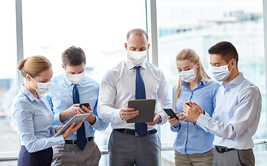 Image showing business people in masks with tablet pc and phones