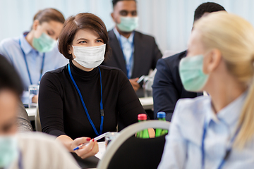 Image showing business people in masks at conference