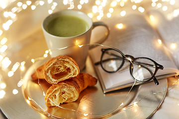 Image showing croissants, matcha tea, book and glasses in bed