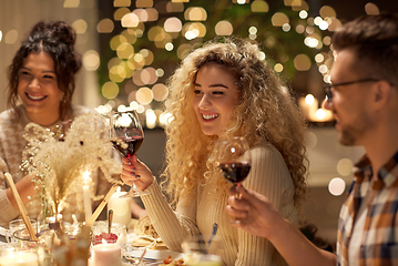 Image showing happy friends drinking red wine at christmas party