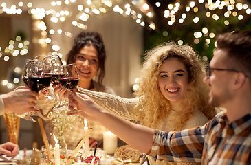 Image showing happy friends drinking red wine at christmas party