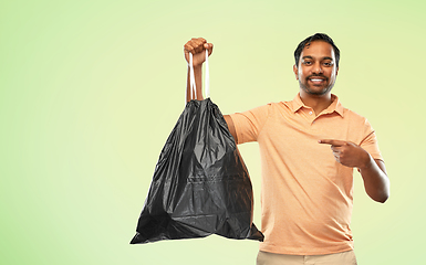 Image showing smiling indian man holding trash bag