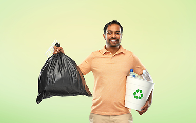 Image showing smiling indian man sorting paper and plastic waste