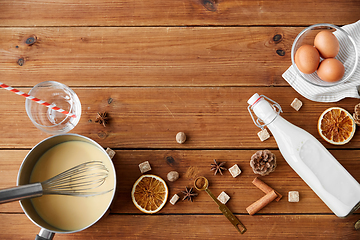 Image showing pot with eggnog, ingredients and spices on wood