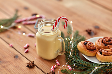 Image showing eggnog with candy cane in mug and cinnamon buns