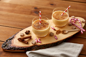 Image showing glasses of eggnog, ingredients and spices on wood