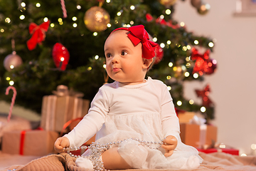 Image showing baby girl at christmas tree with gifts at home