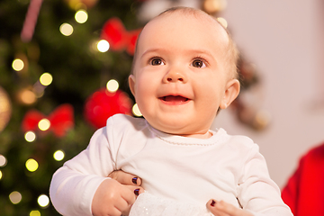 Image showing smiling baby girl over christmas tree lights