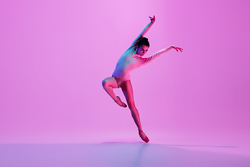 Image showing Young and graceful ballet dancer isolated on pink studio background in neon light. Art, motion, action, flexibility, inspiration concept.