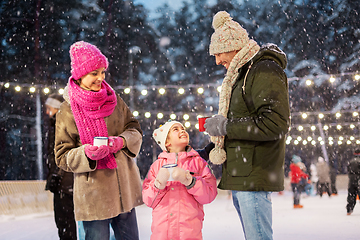 Image showing happy family drinking hot tea on skating rink