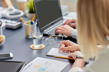 Image showing woman with notebook working on ui design at office