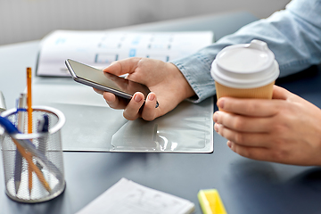 Image showing woman with coffee using smartphone at office