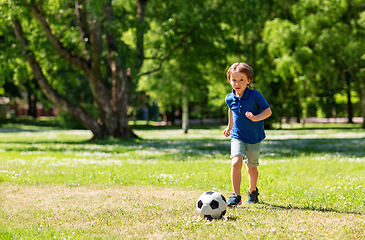 Image showing happy little boy with ball playing soccer at park