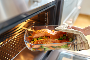 Image showing woman cooking food in oven at home kitchen