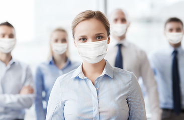 Image showing businesswoman in mask with colleagues in office