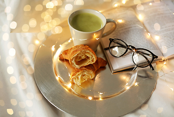 Image showing croissants, matcha tea, book and glasses in bed