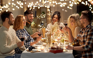 Image showing happy friends drinking red wine at christmas party