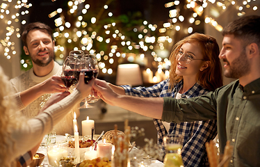 Image showing happy friends drinking red wine at christmas party