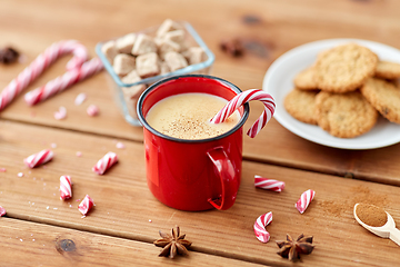 Image showing cup of eggnog with candy cane, cookies and sugar