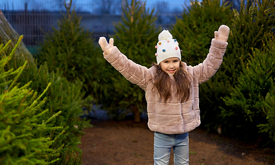 Image showing little girl choosing christmas tree at market