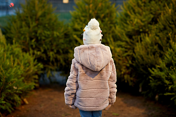 Image showing little girl choosing christmas tree at market