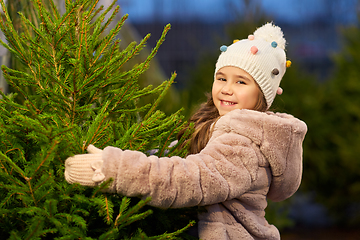 Image showing little girl choosing christmas tree at market