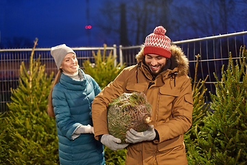 Image showing happy couple buying christmas tree at market