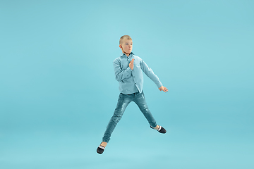 Image showing Childhood and dream about big and famous future. Pretty little boy isolated on blue background